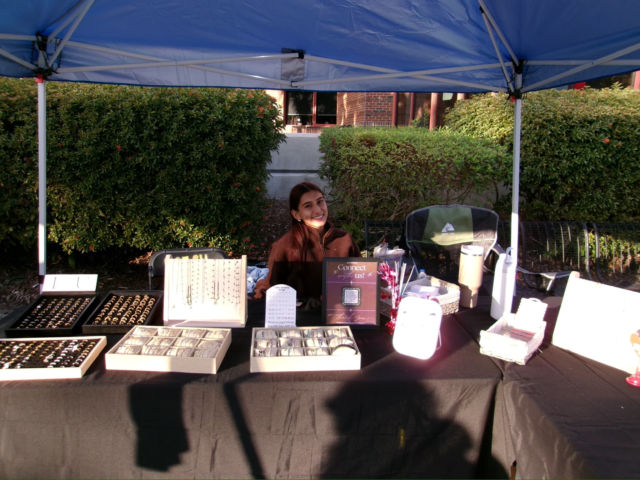 Krystal Jewels at a local student market, rings and chains laid out on the table